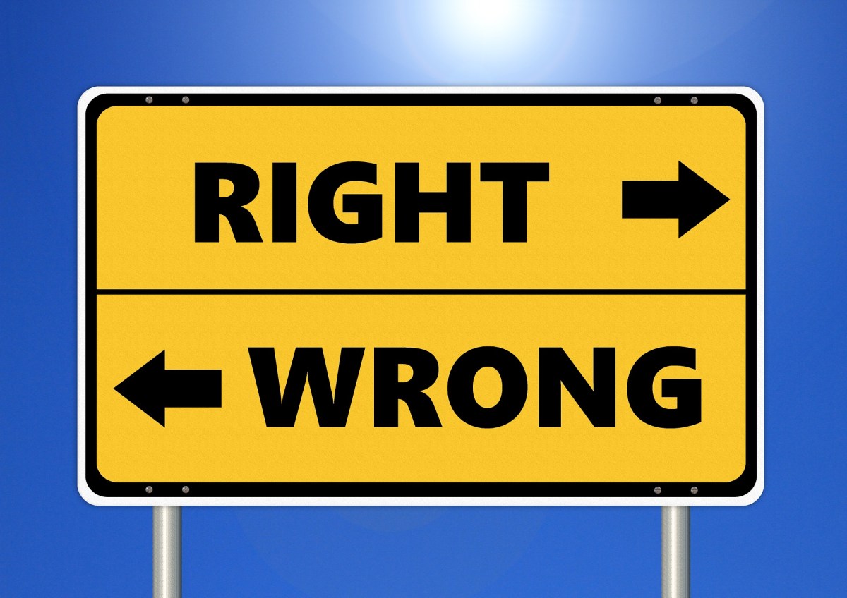 A yellow rectangular road sign features a top section reading "RIGHT" with an arrow pointing right and a bottom section reading "WRONG" with an arrow pointing left, set against a solid blue background.